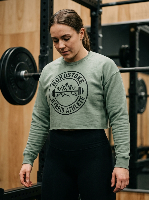 Female hybrid athlete wearing the Nordstoke Badge cropped sweatshirt in a gym