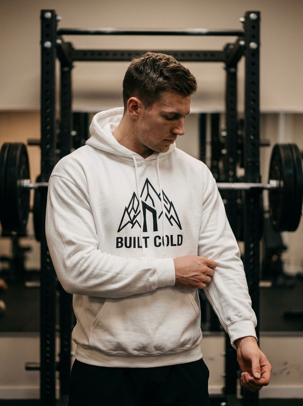 Male hybrid athlete wearing the Nordstoke Built Cold hoodie with Norse mountain print in a gym