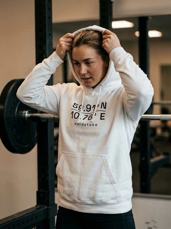 Female hybrid athlete wearing the Nordstoke women's hoodie in a gym