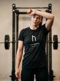 Female hybrid athlete wearing the Nordstoke women's performance tee in a gym