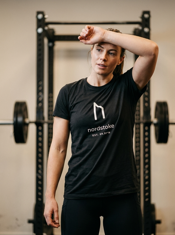 Female hybrid athlete wearing the Nordstoke women's performance tee in a gym