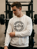 Hybrid athlete wearing the Nordstoke Badge crewneck with Norse barbell emblem in a gym