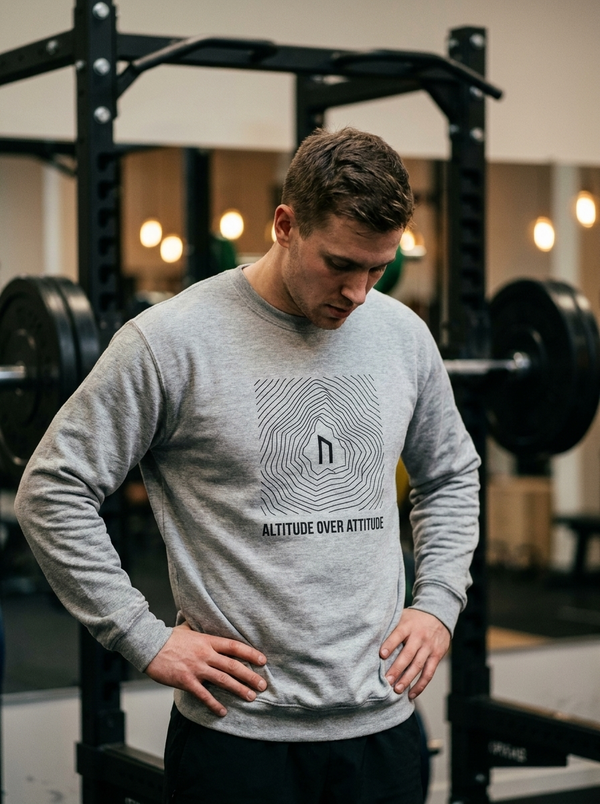 Hybrid athlete wearing the Nordstoke Altitude crewneck with topographic summit print in a gym