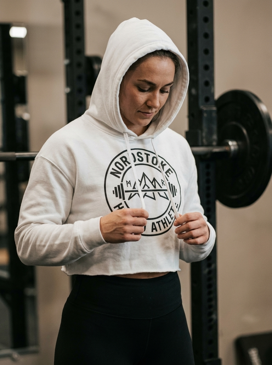 Female hybrid athlete wearing the Nordstoke Badge cropped hoodie in a gym